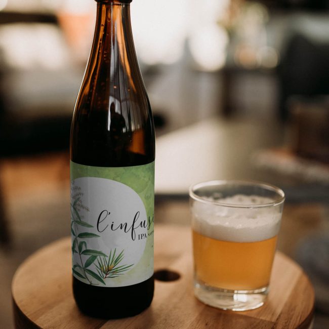 Verre rempli de biere avec bouteille a coté sur un tabouret