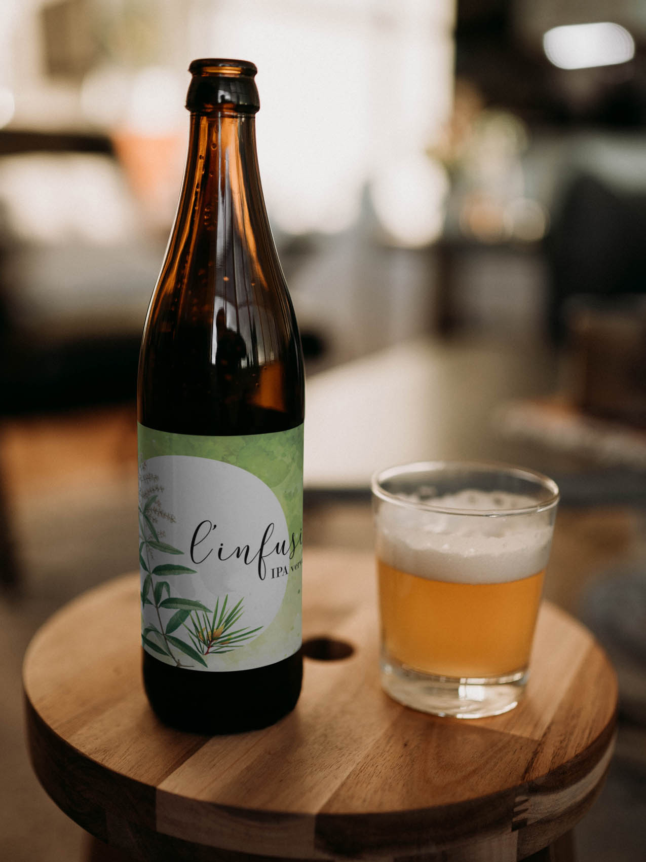 Verre rempli de biere avec bouteille a coté sur un tabouret