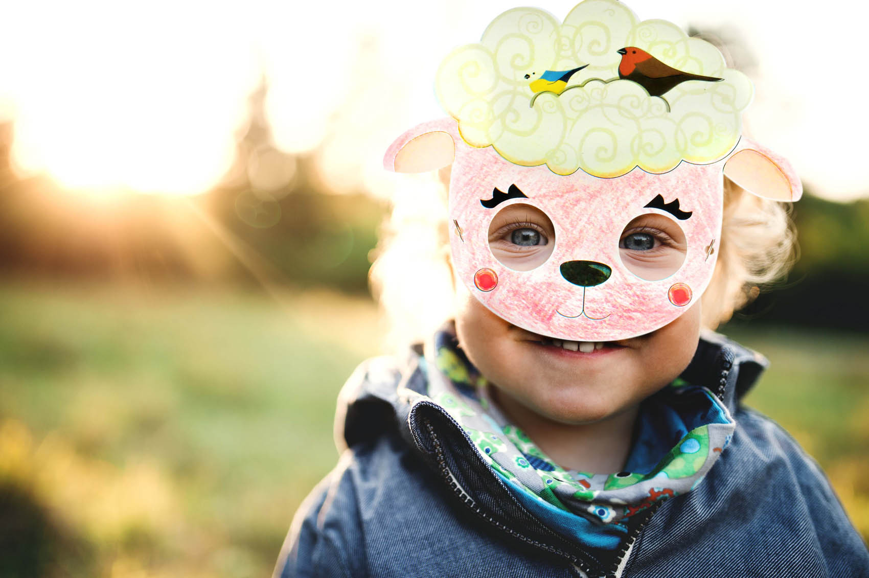 Enfant qui porte un masque mouton colorié avec fond vert