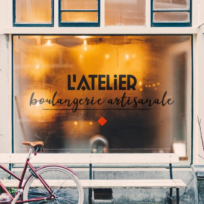 Vitrine d'une boulangerie artisanale avec logo sur la vitre.