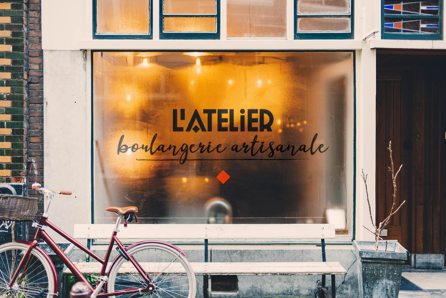 Vitrine d'une boulangerie artisanale avec logo sur la vitre.