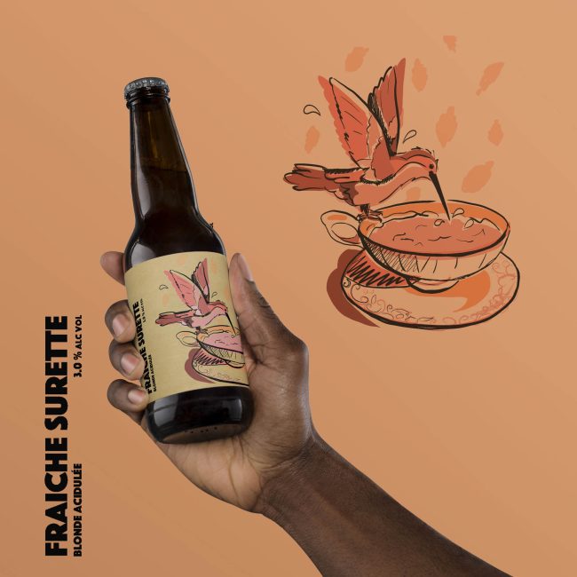 Bière artisanale tenue dans une main d'une personne noire avec illustration colibri sur fond orange