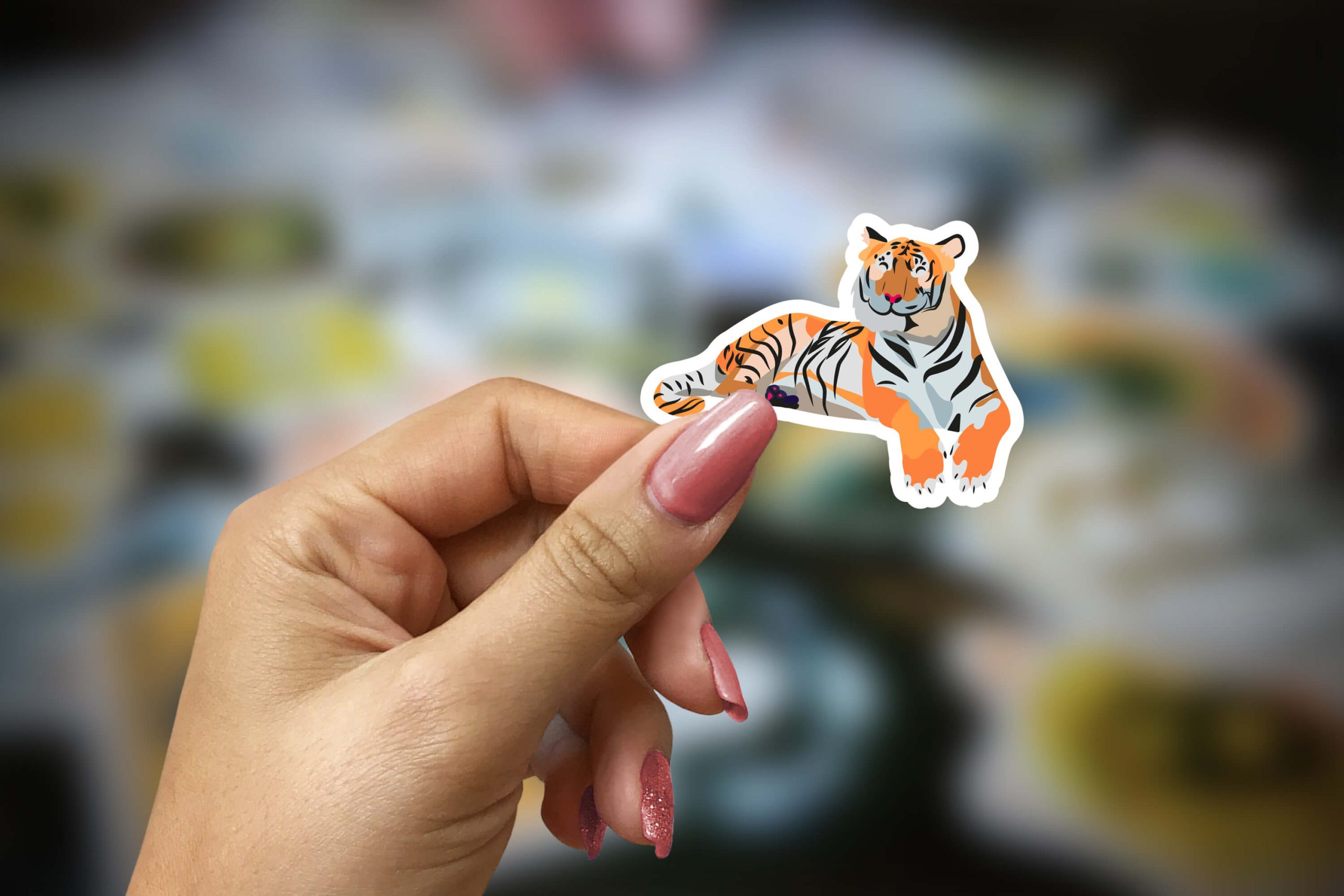 Main de femme qui tient un sticker tigre dans les mains